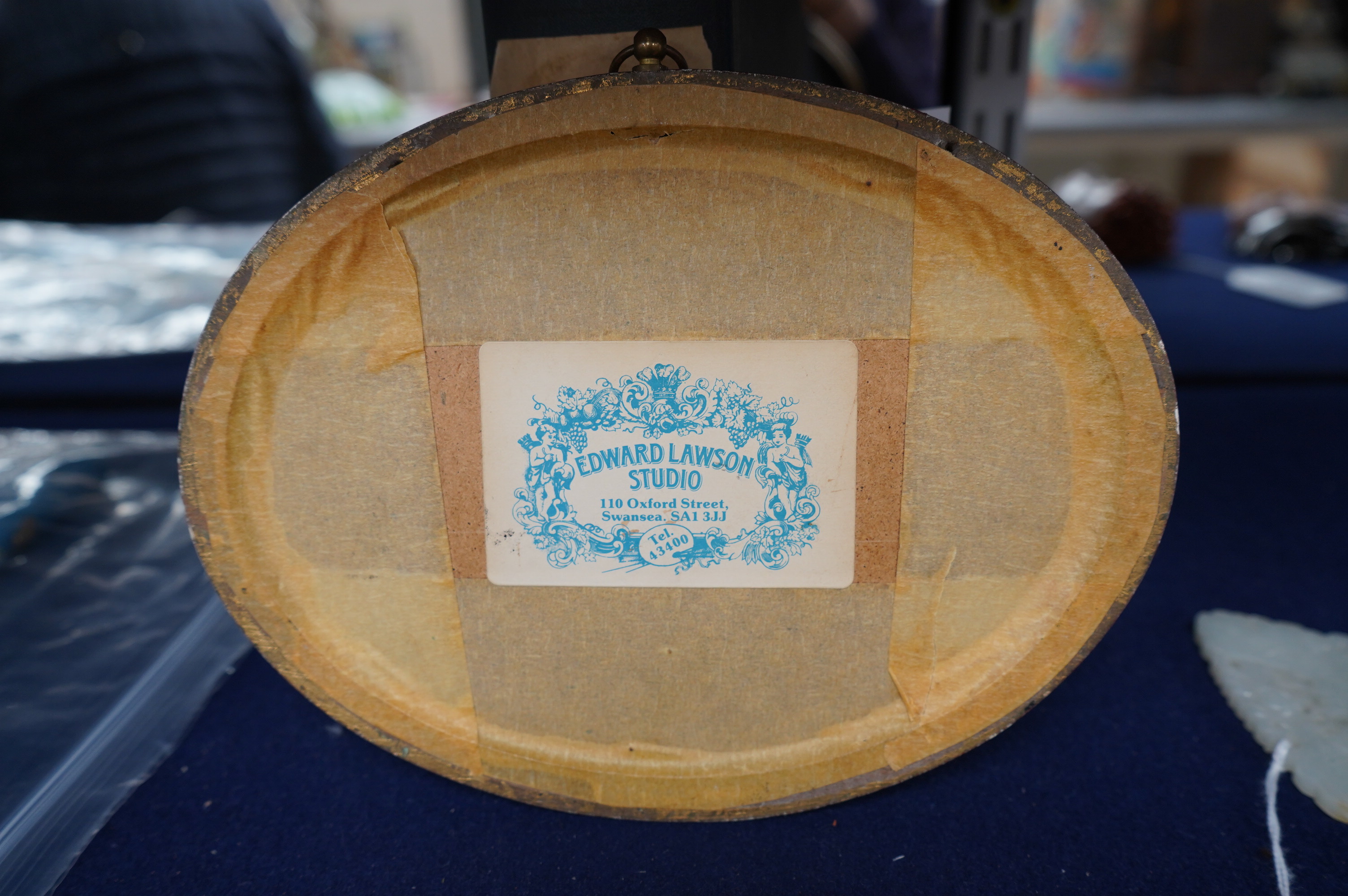 Two 17th century finely embroidered needlework fragments, possibly originally part of a casket or sampler, depicting a butterfly and flower on one and a bird and fruit on the other, in an oval gilt frame, largest fragmen